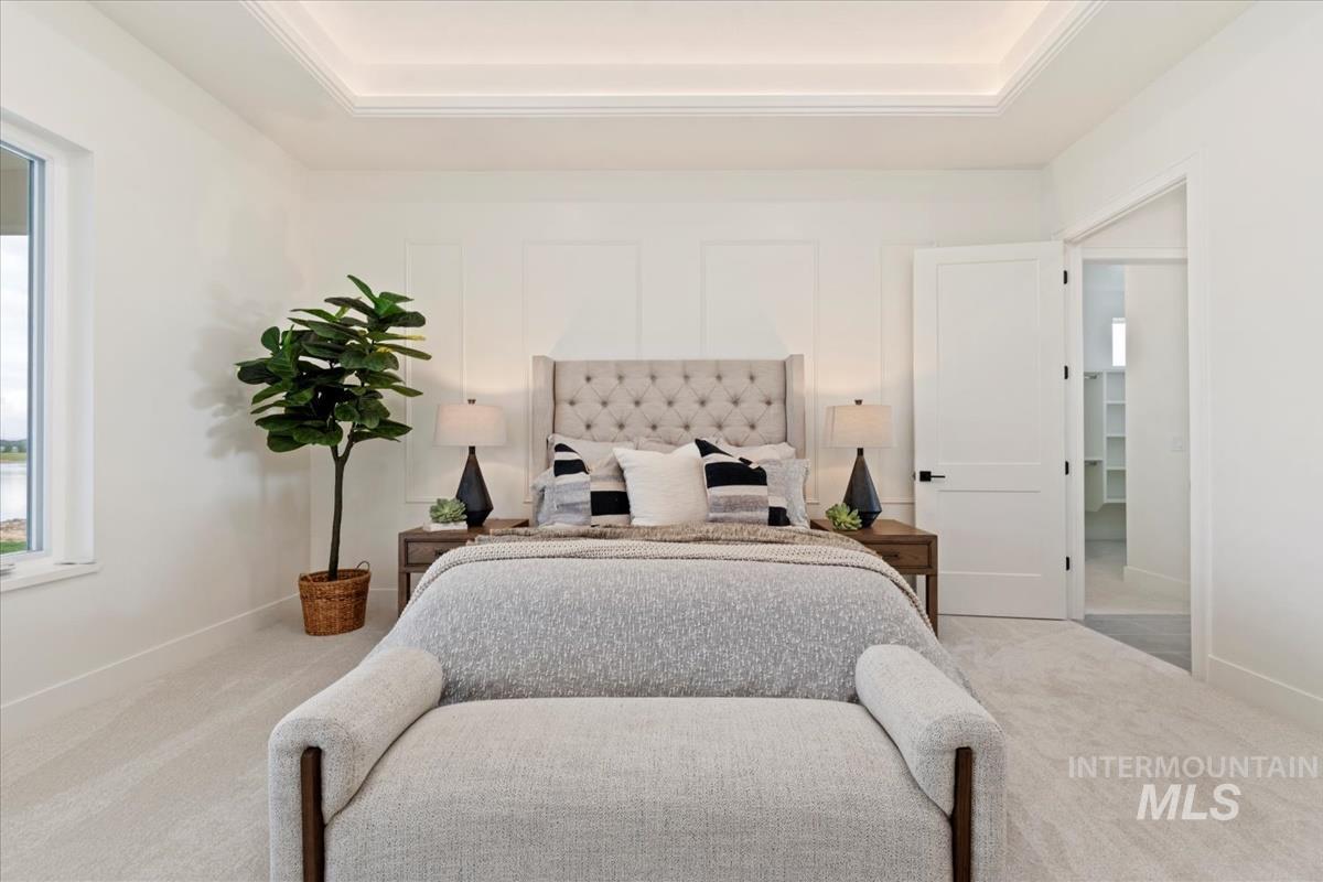 Bedroom featuring carpet and a raised ceiling