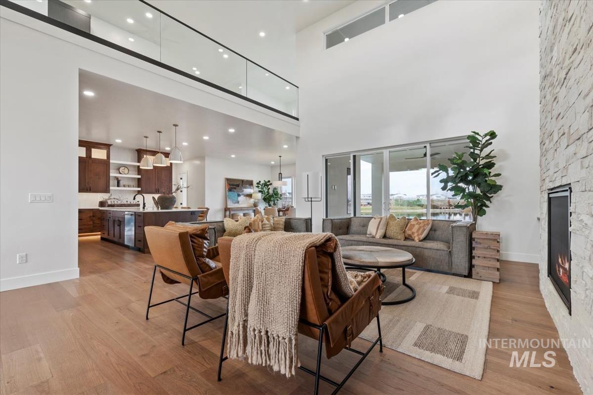 Living room featuring a fireplace, light wood finished floors, and a high ceiling