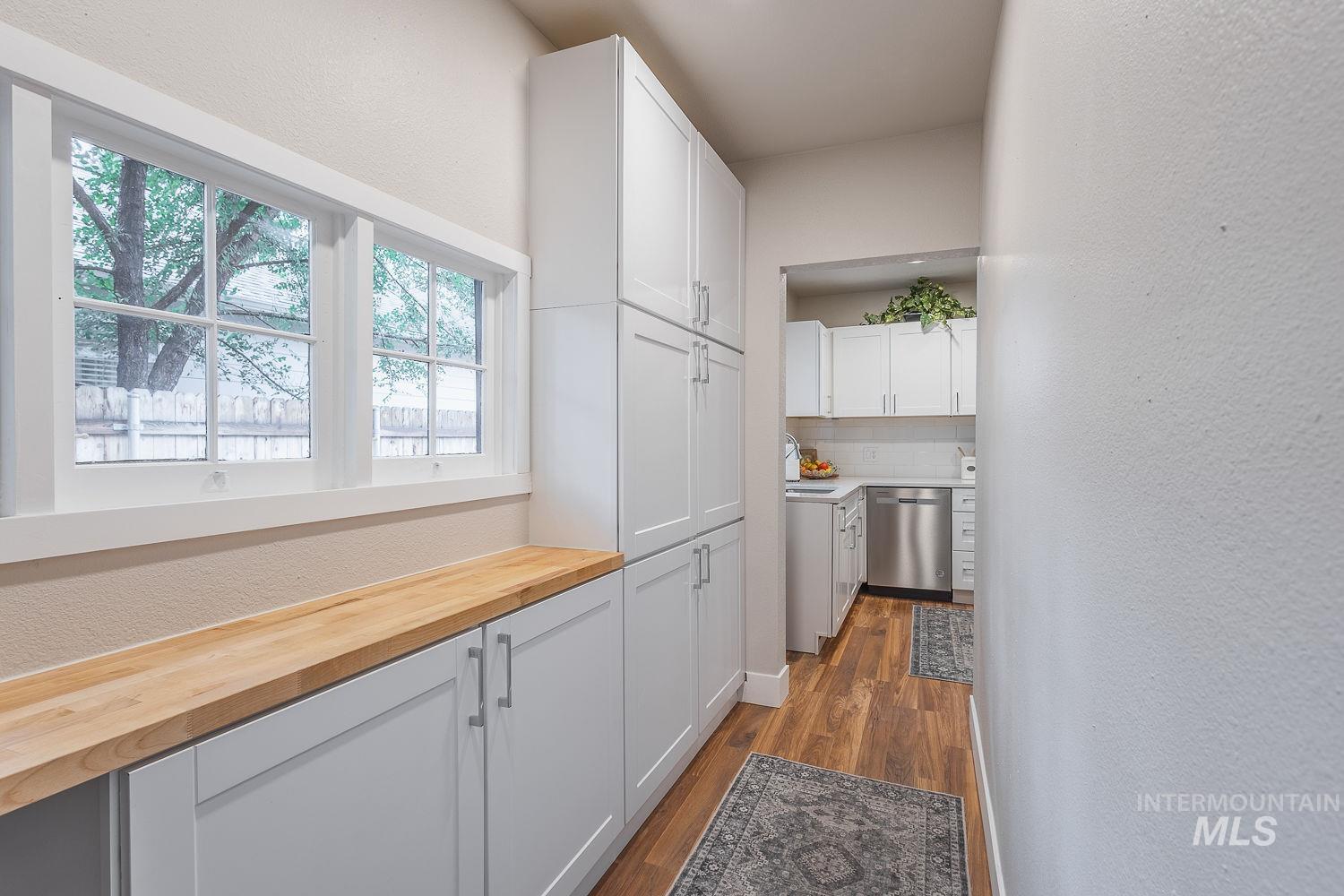 Corridor with a textured wall and dark wood-style floors