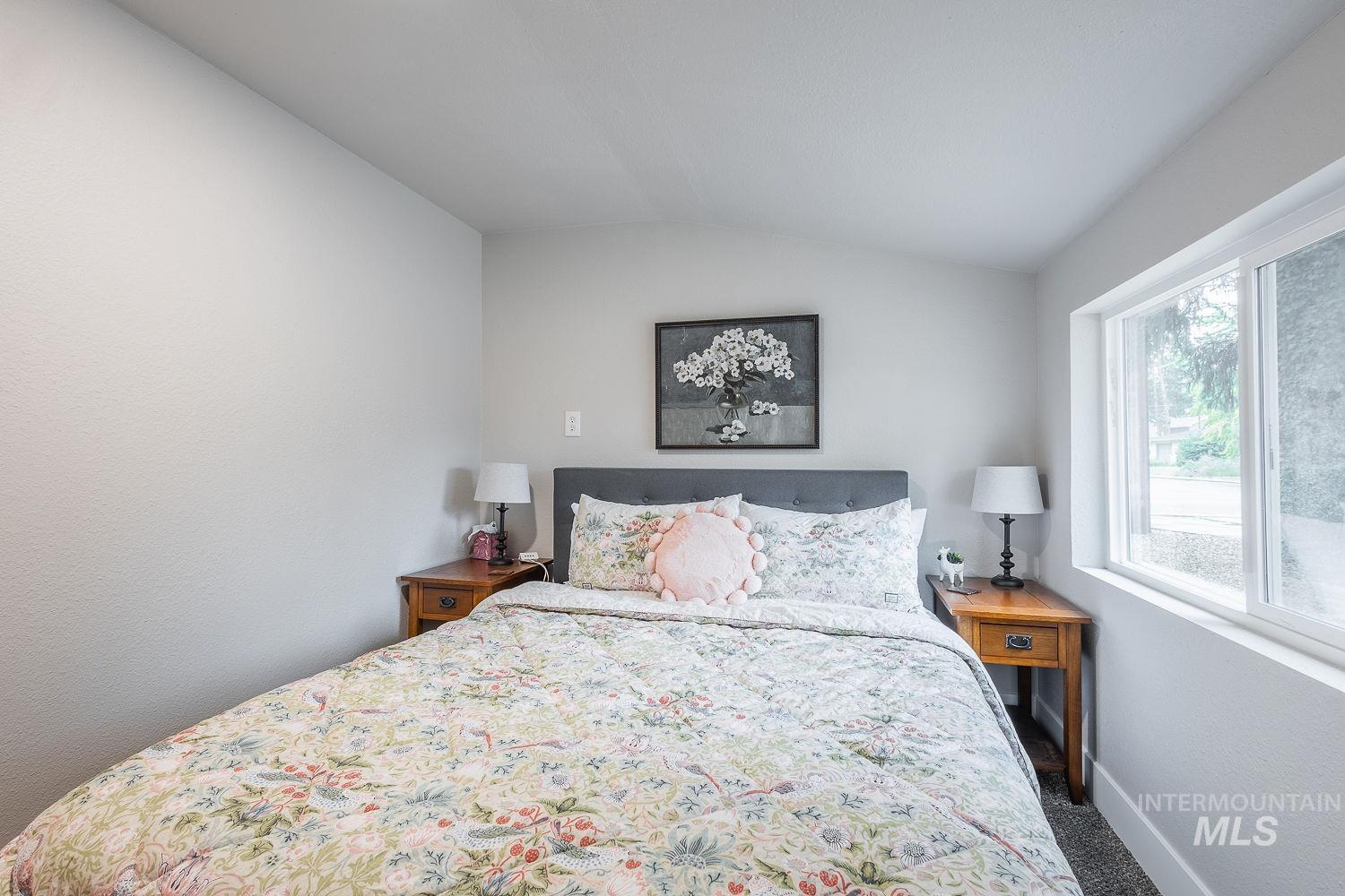 Bedroom featuring lofted ceiling and carpet flooring