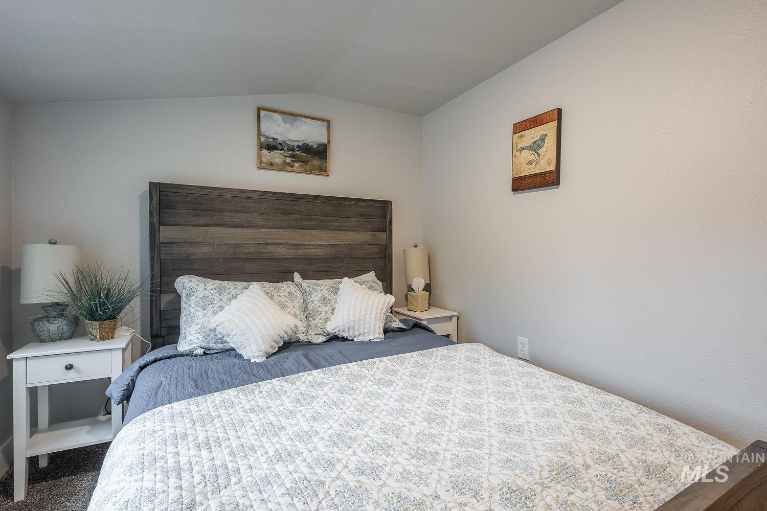 Carpeted bedroom with lofted ceiling