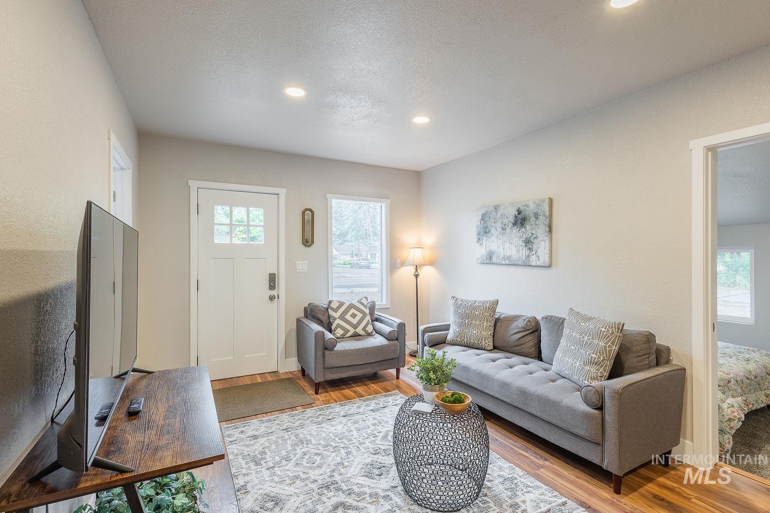 Living room with wood finished floors, recessed lighting, and a textured ceiling