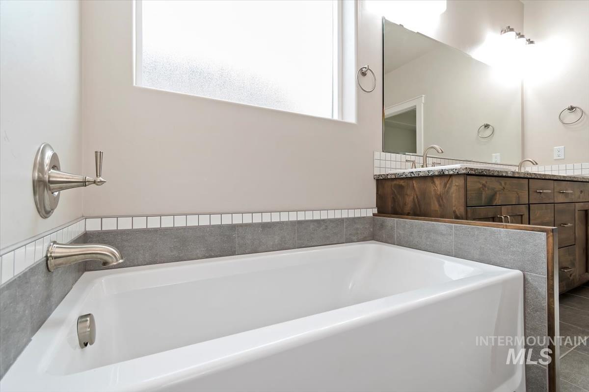Full bathroom with double vanity and a bath