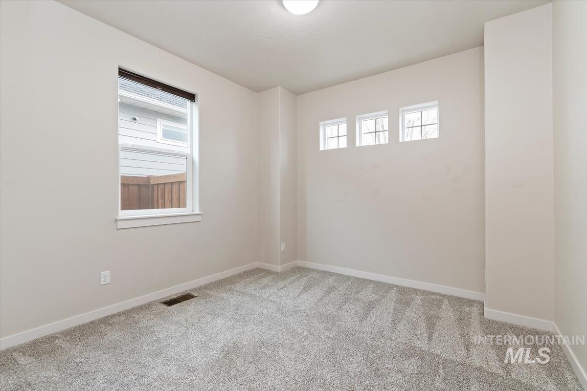 Unfurnished room featuring light colored carpet and baseboards