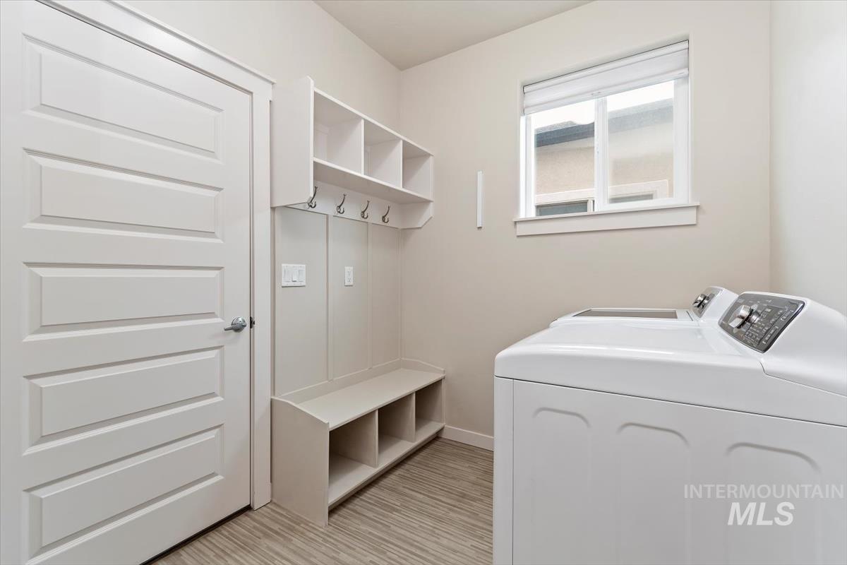 Washroom featuring independent washer and dryer and baseboards