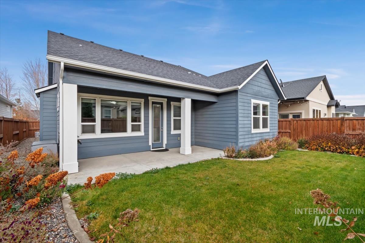 Rear view of property featuring a patio and a shingled roof