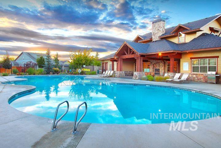 Pool at dusk with a patio, a community pool, and area for grilling