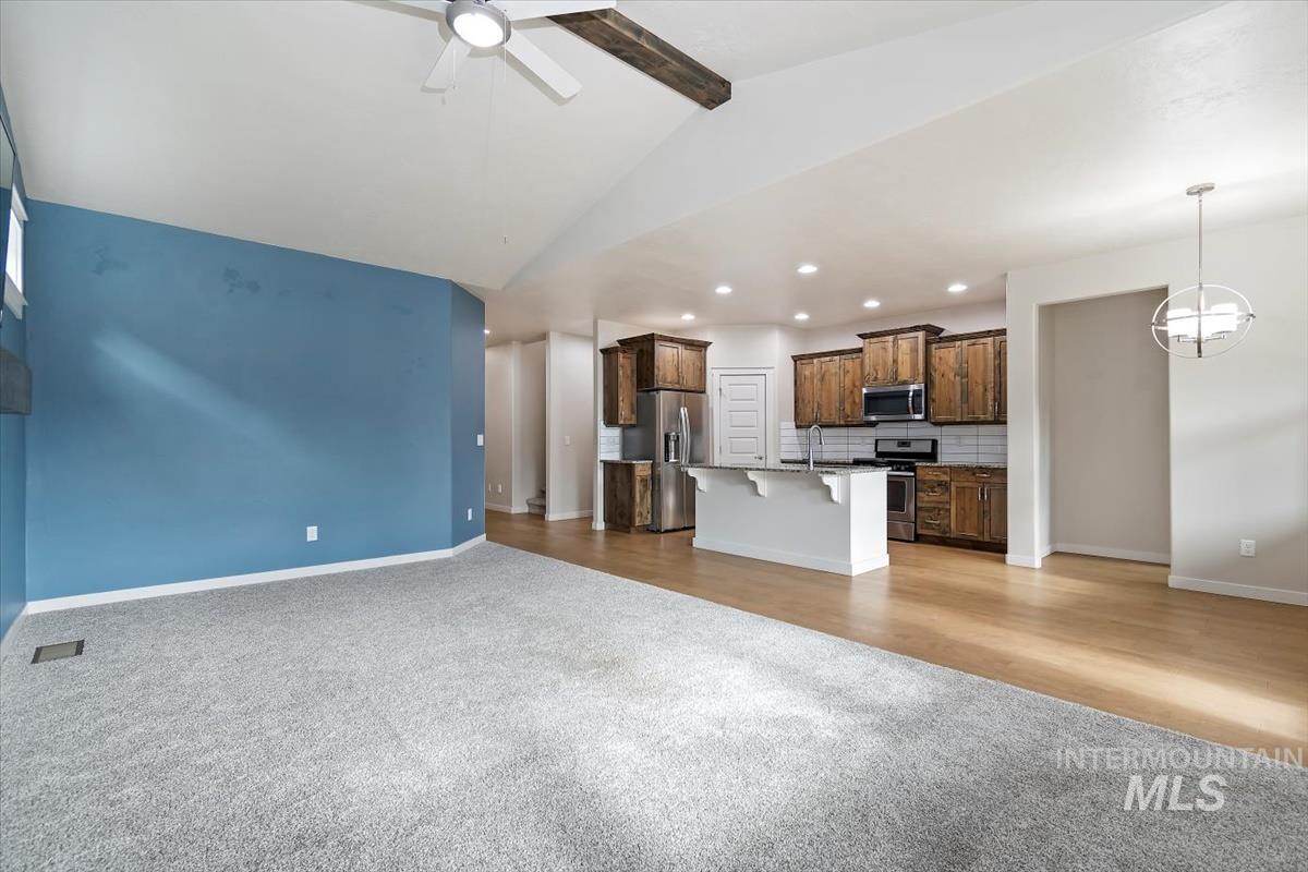Unfurnished living room with light carpet, ceiling fan, recessed lighting, and light wood-type flooring
