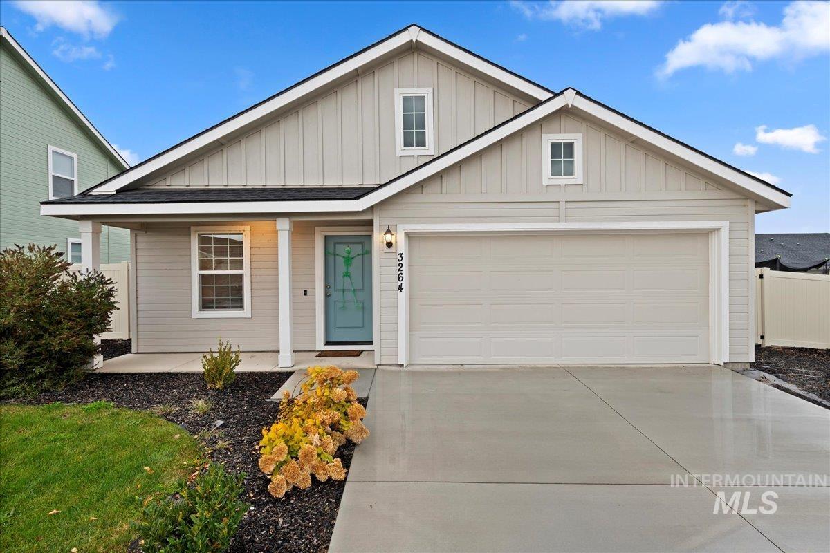 View of front facade featuring board and batten siding, covered porch, concrete driveway, and an attached garage