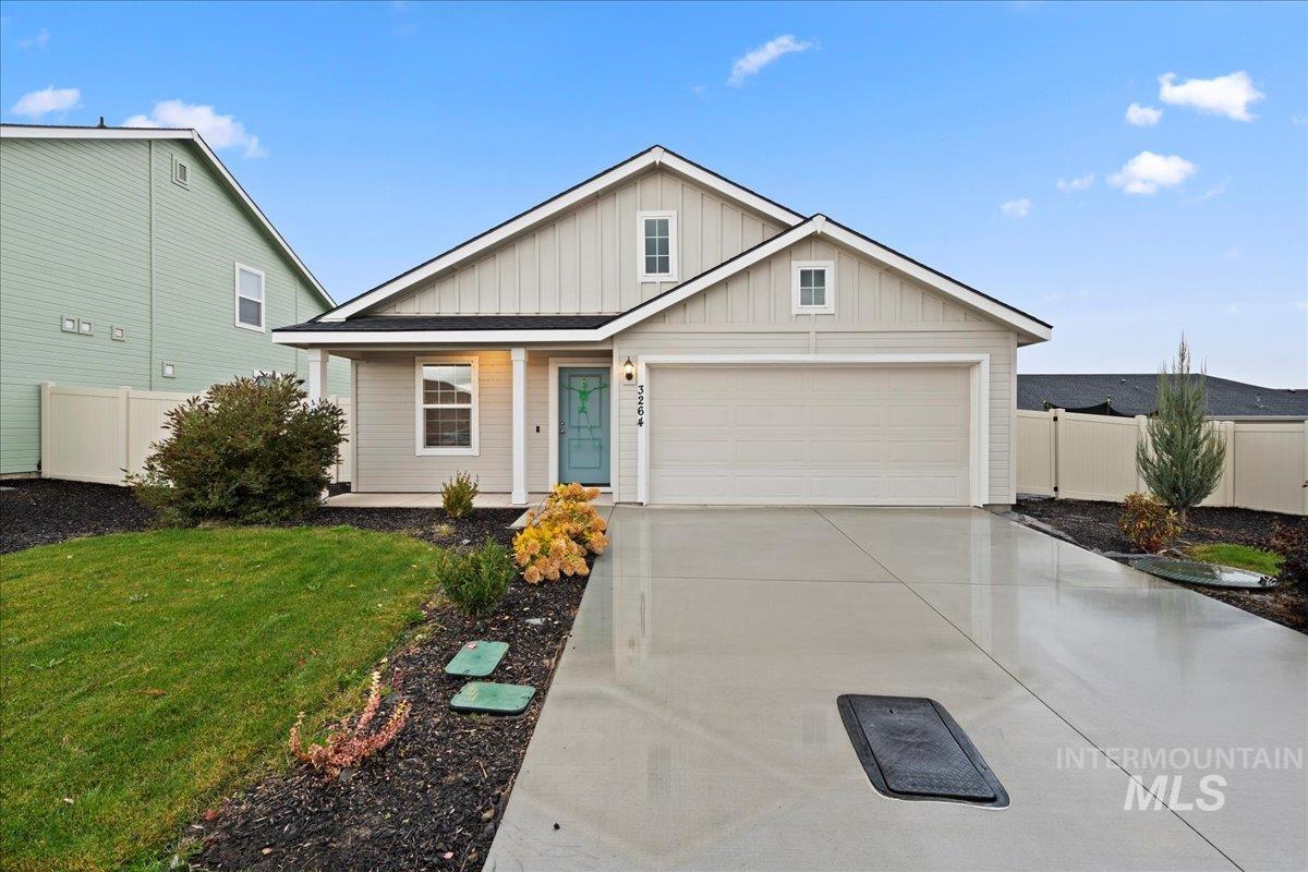 View of front of house with board and batten siding, driveway, and an attached garage