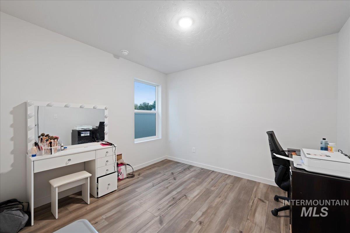 Home office with light wood finished floors and a textured ceiling