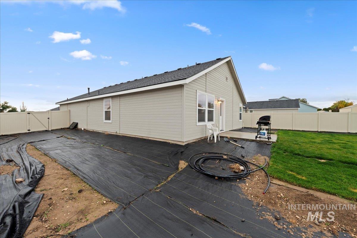 Rear view of house featuring a wooden deck, a fenced backyard, and a gate