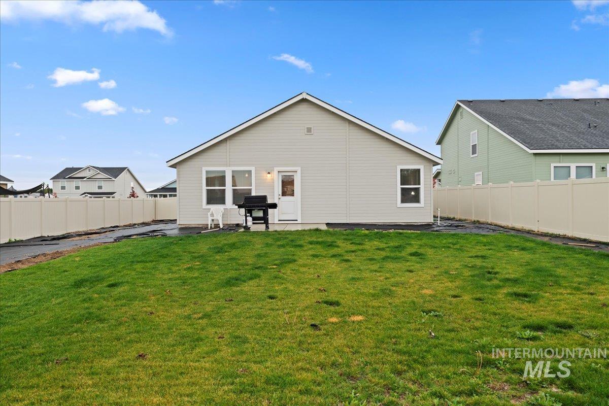 Rear view of house featuring a fenced backyard and a patio area