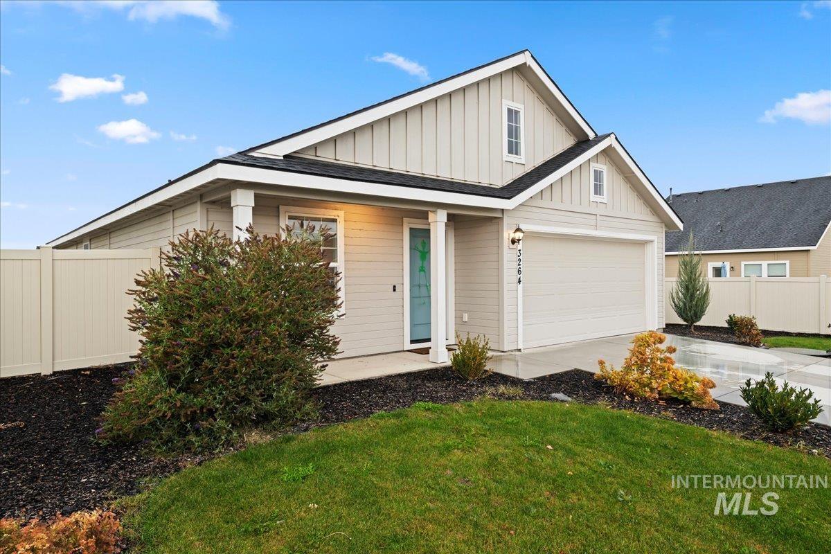 View of front of property with board and batten siding, a garage, and concrete driveway