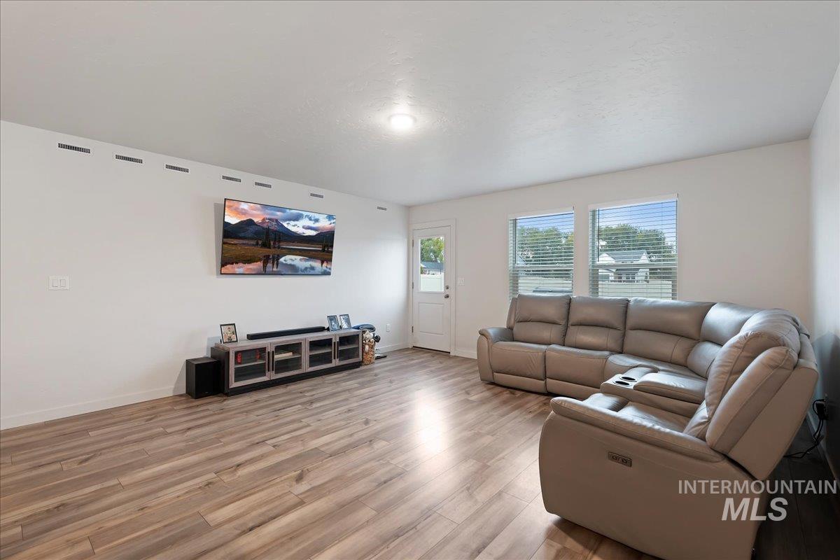 Living room featuring light wood-type flooring and baseboards