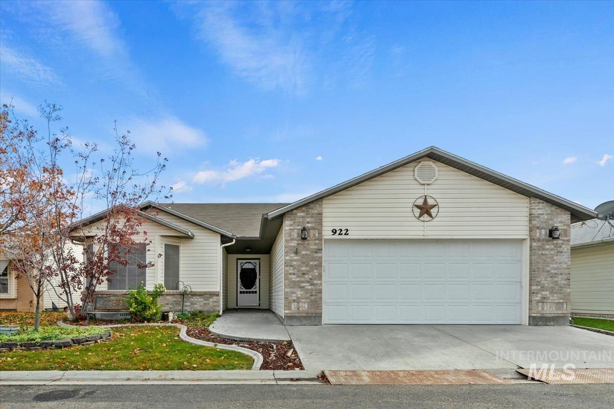 Single story home with brick siding, a garage, and concrete driveway