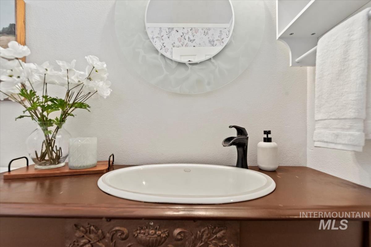 Bathroom with a textured wall and vanity