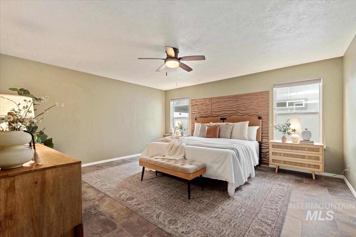 Bedroom featuring a ceiling fan and a textured ceiling