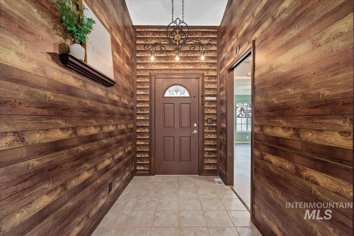 Entryway featuring wooden walls and tile patterned floors