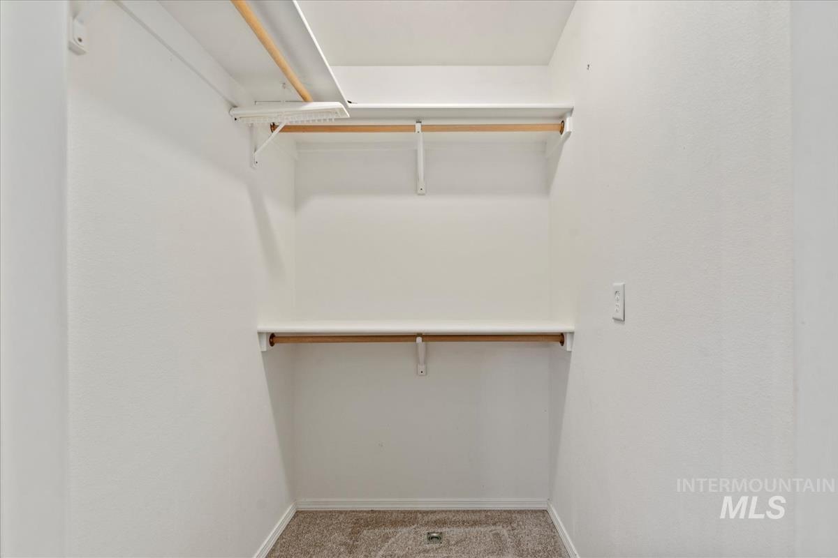 Walk in closet with light colored carpet