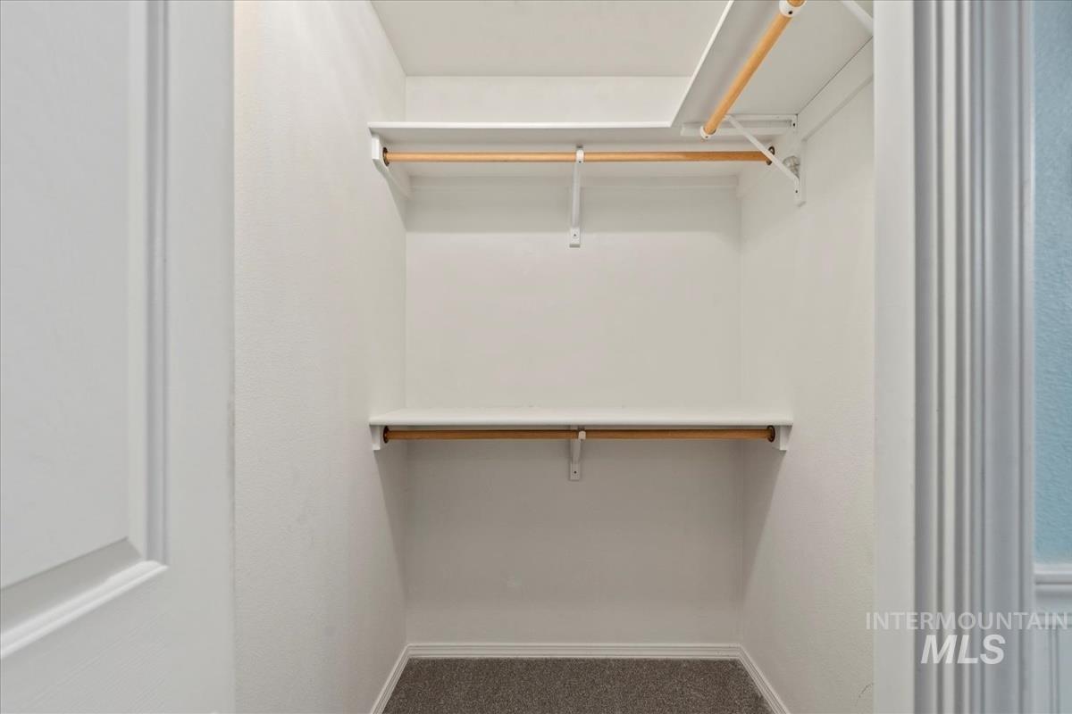 Walk in closet with dark colored carpet