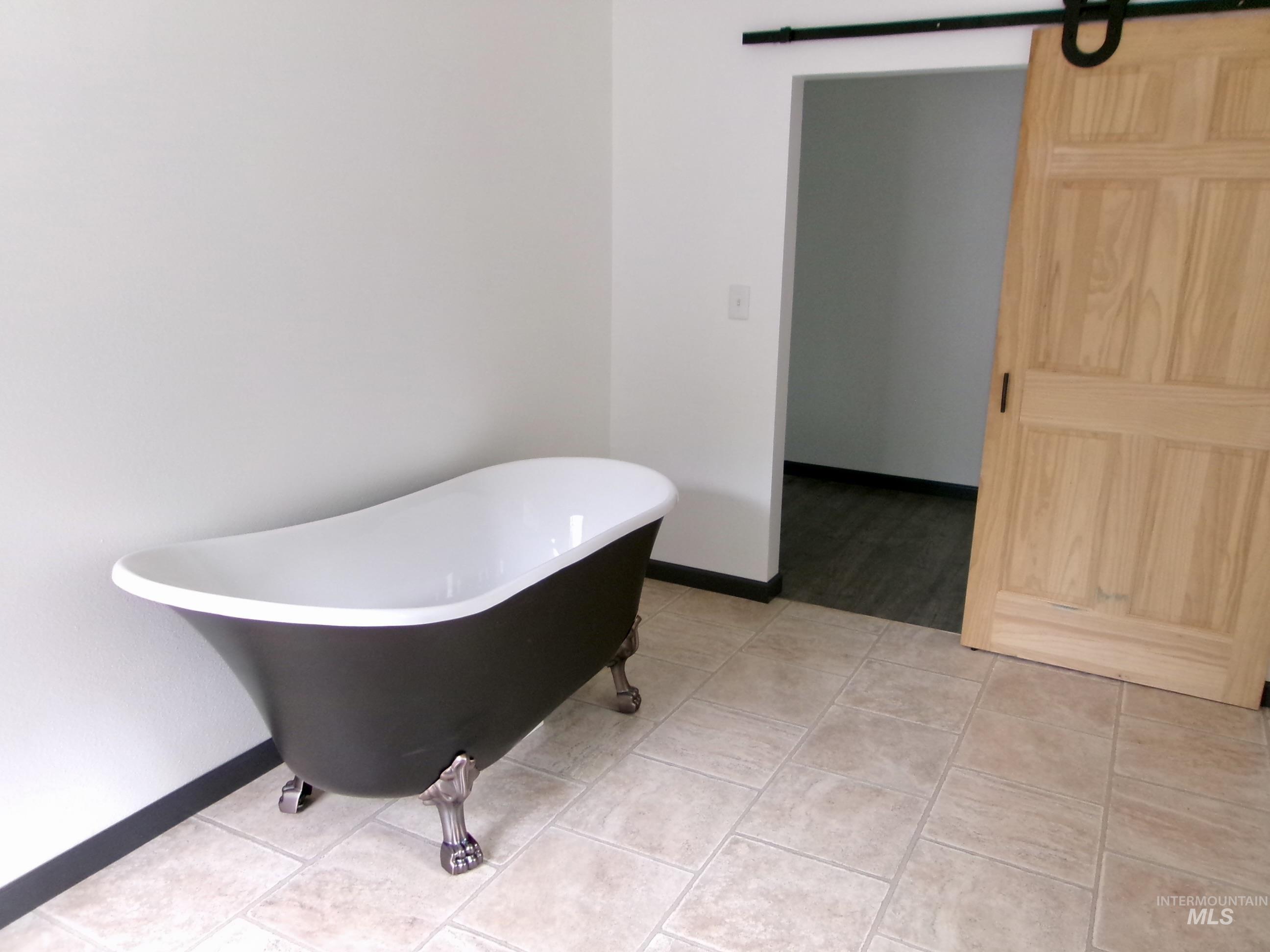 Bathroom featuring a freestanding tub and light tile patterned floors