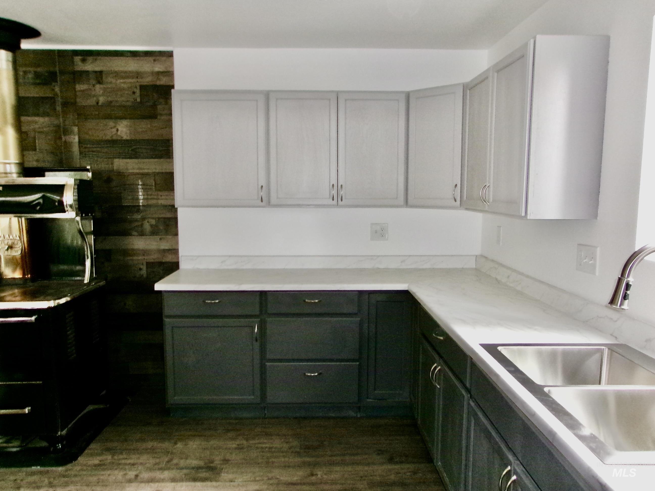 Kitchen featuring green cabinets, light countertops, and dark wood finished floors