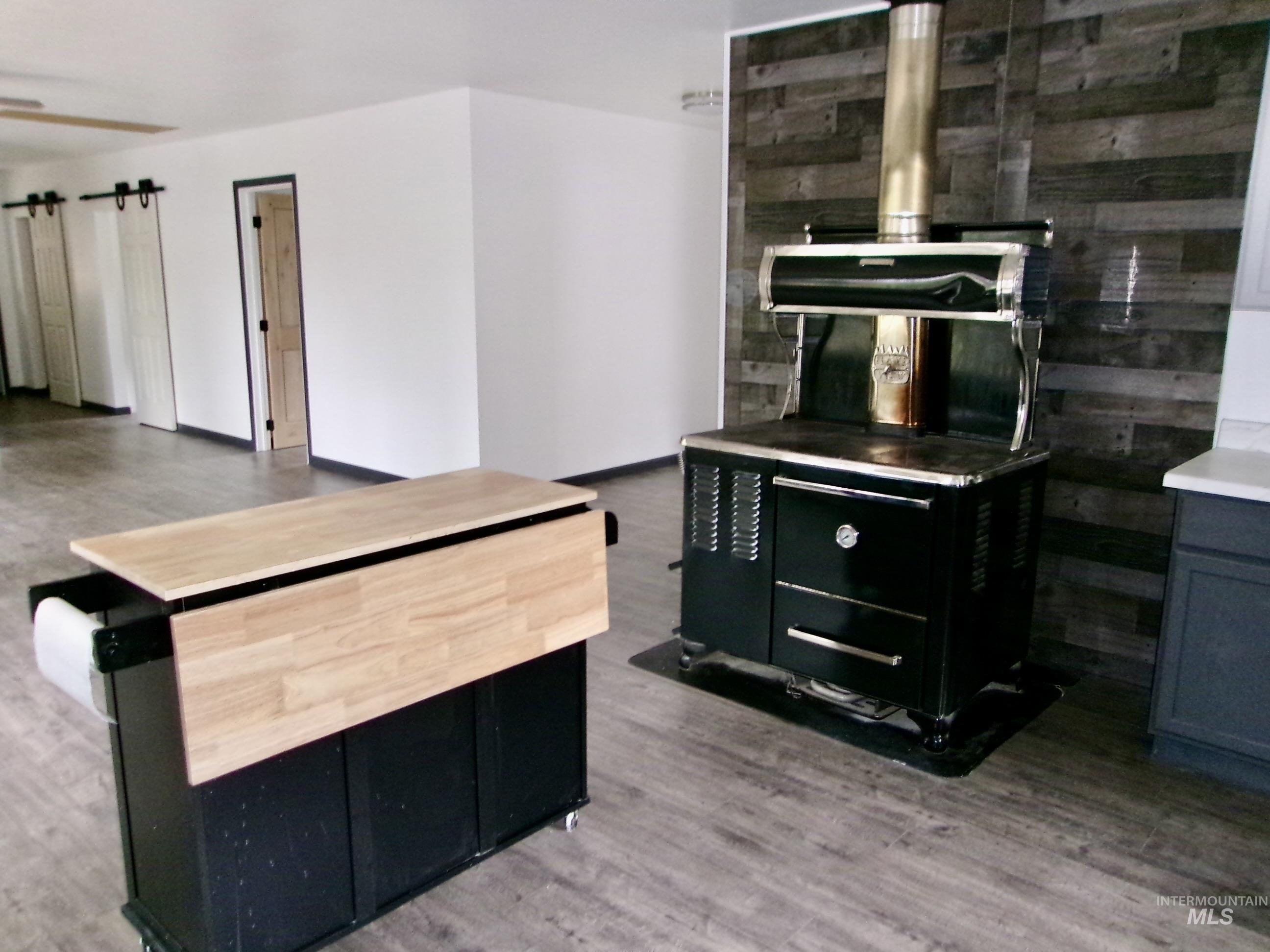 Kitchen featuring dark cabinets, dark wood-type flooring, and butcher block counters