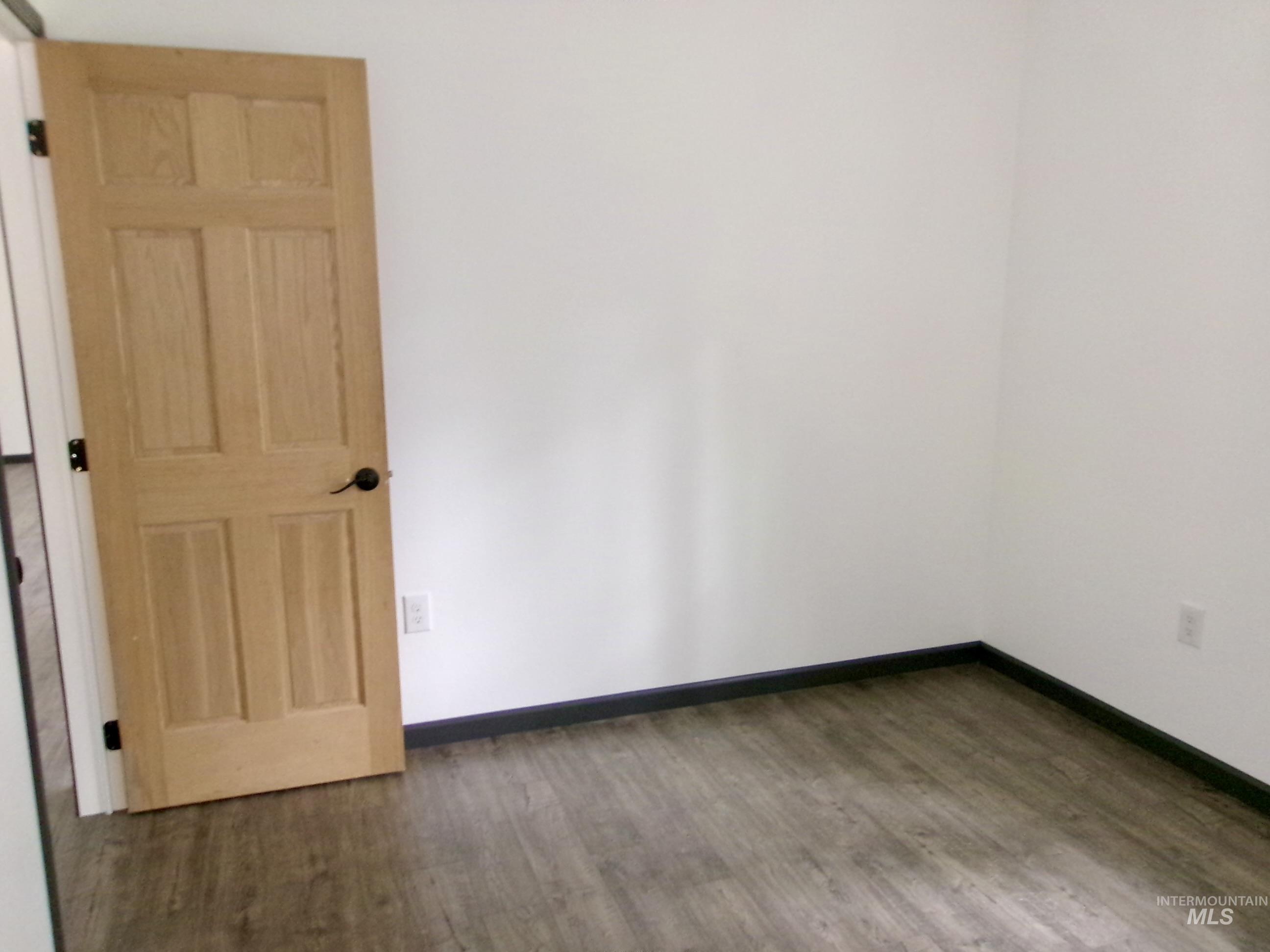 Unfurnished room featuring wood finished floors and baseboards