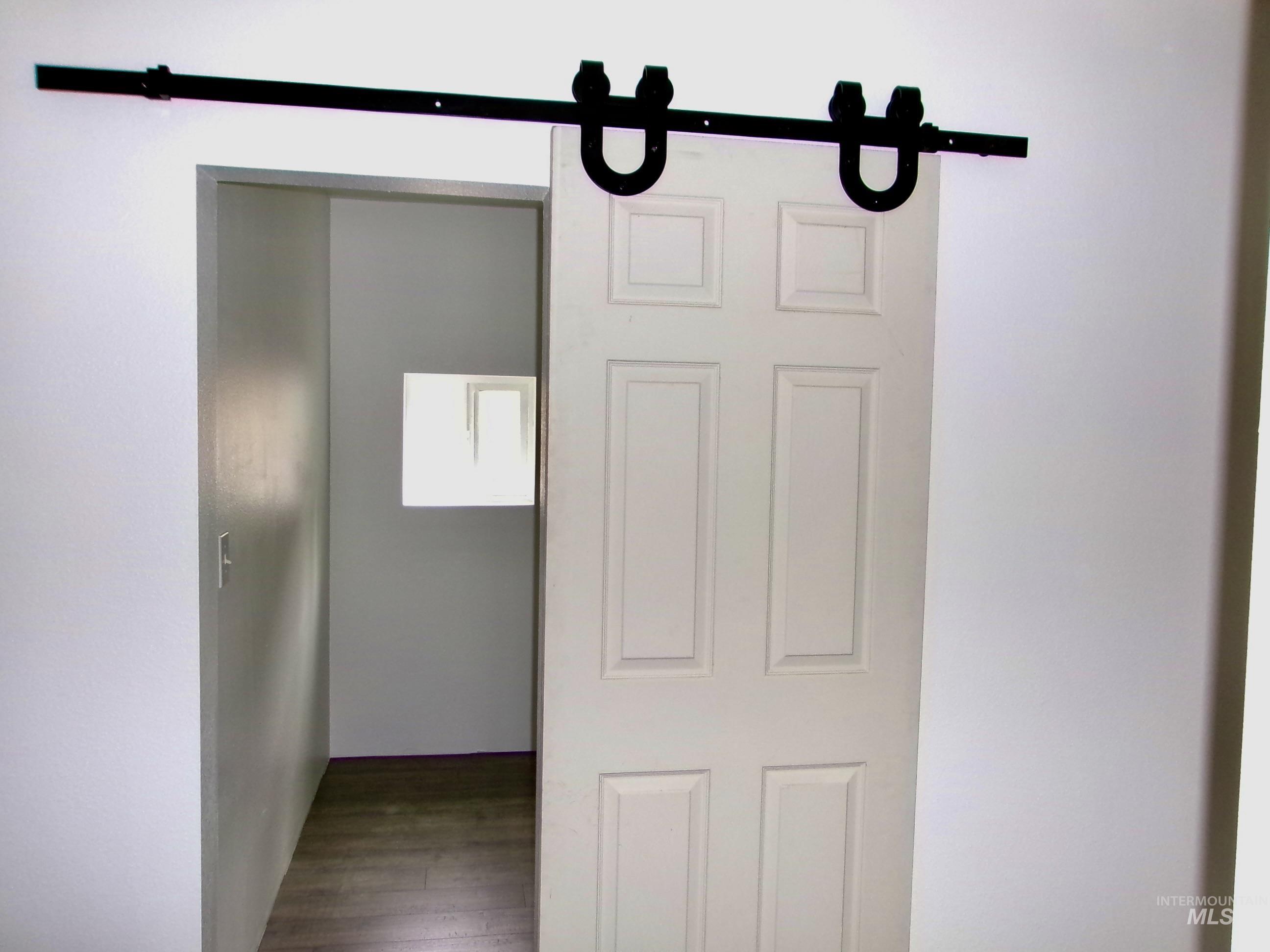 Detailed view of wood finished floors and a barn door