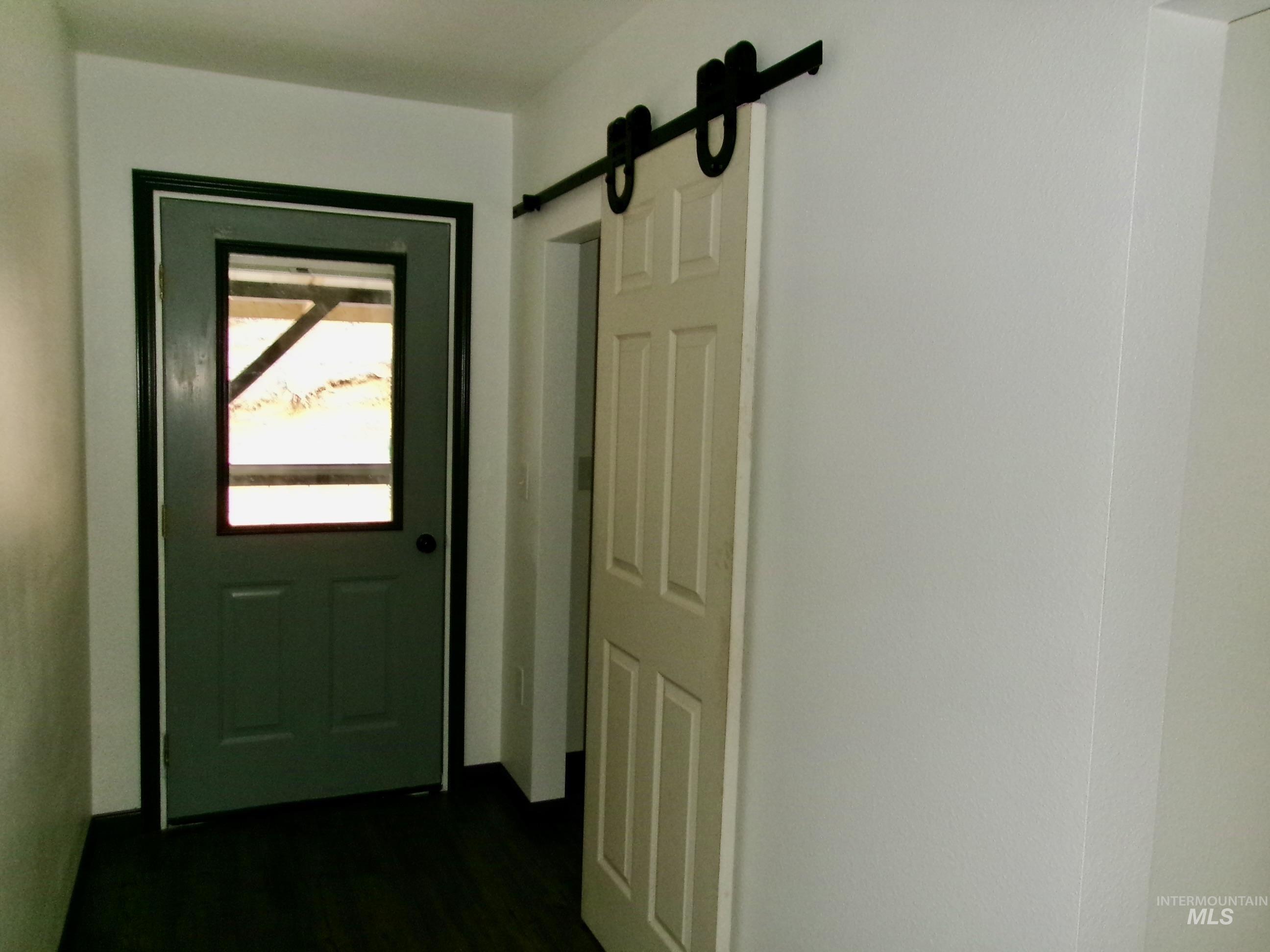 Doorway to outside featuring a barn door and wood finished floors