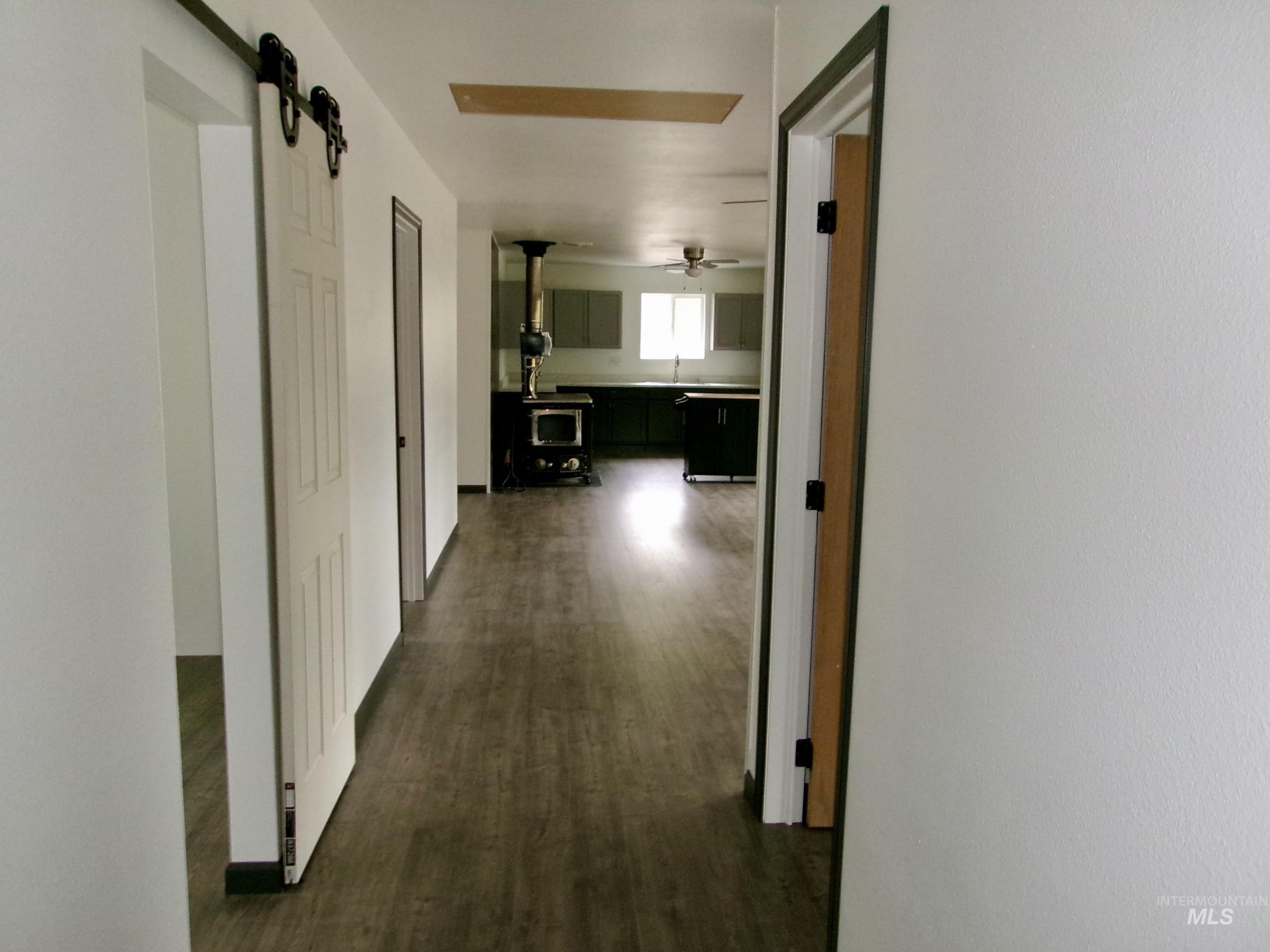 Hallway featuring a barn door and dark wood finished floors