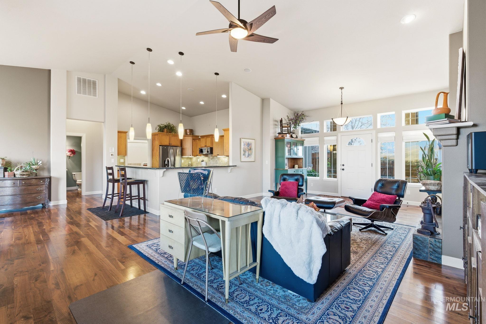 Living room featuring high vaulted ceiling, dark wood-style flooring, a ceiling fan, and recessed lighting