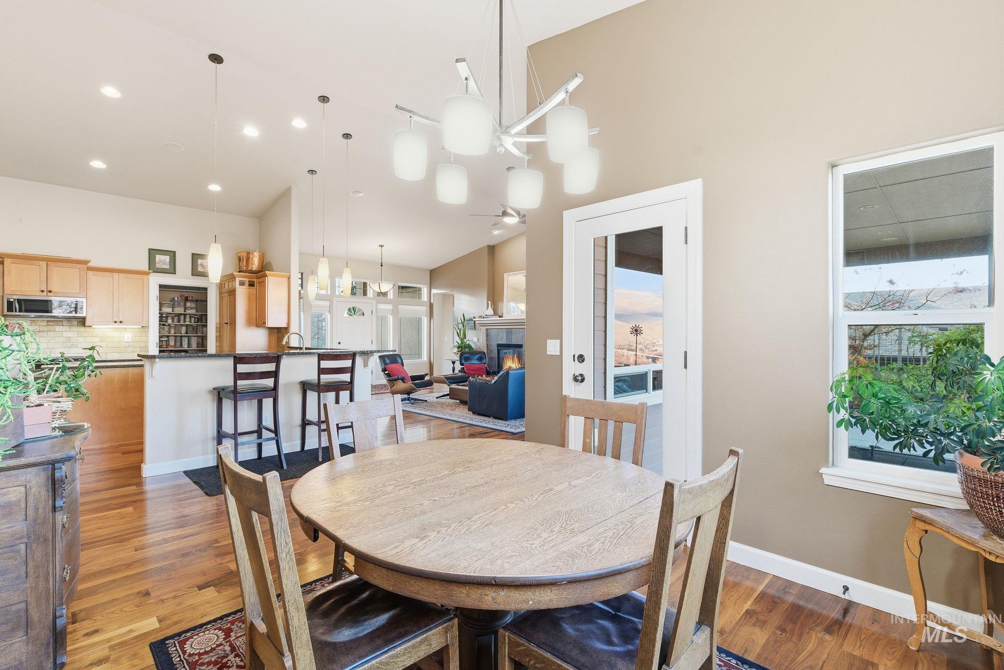 Dining space with light wood-style flooring, a glass covered fireplace, and a chandelier