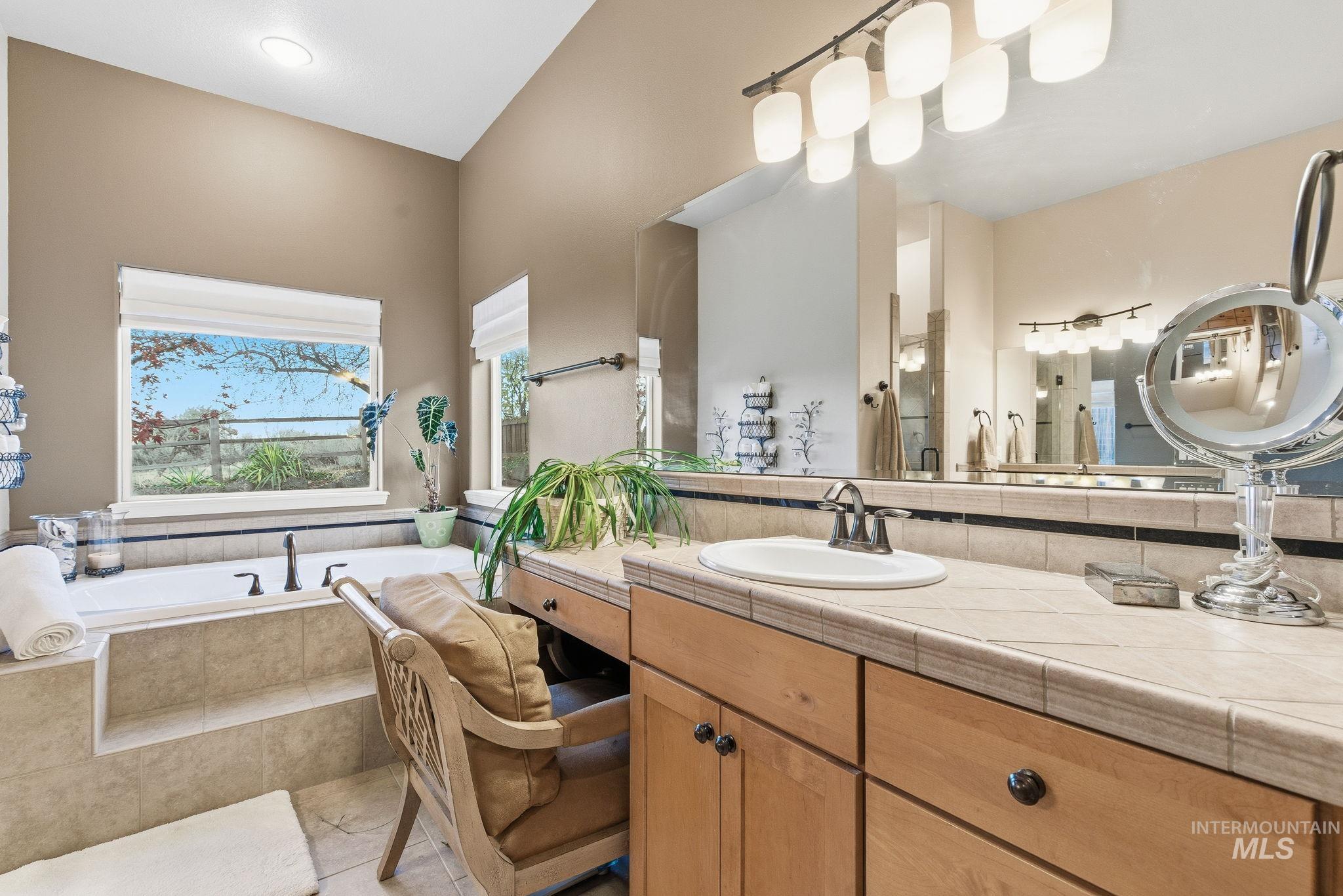 Full bathroom featuring a bath, vanity, and light tile patterned flooring