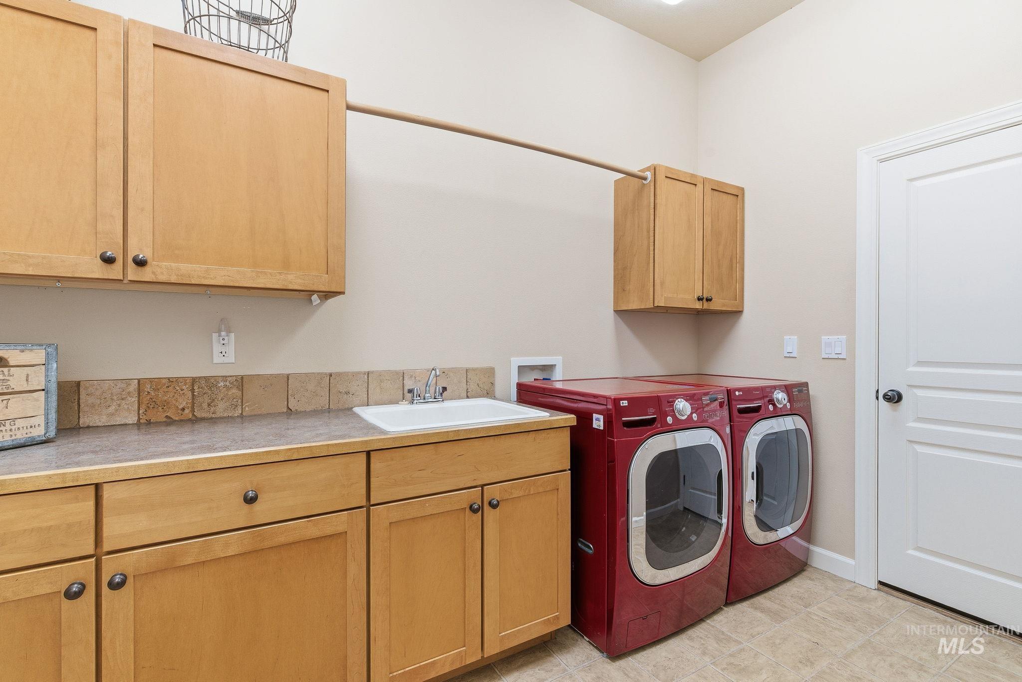 Laundry area with cabinet space and washing machine and clothes dryer