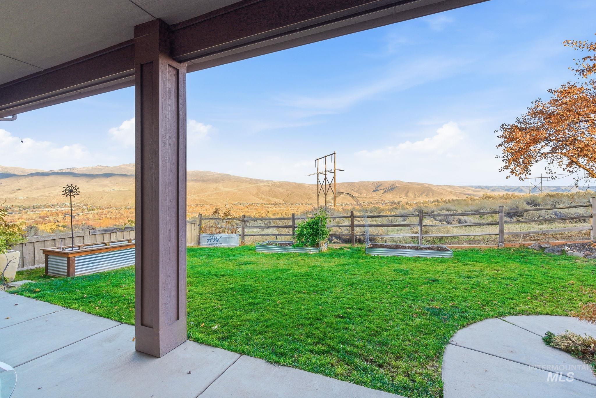 View of yard featuring a mountain view, a patio, and a view of countryside