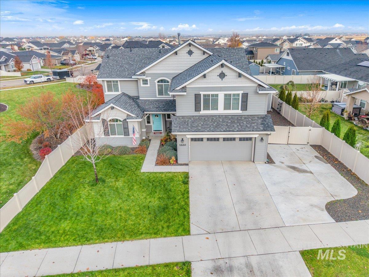 Craftsman-style home featuring a fenced backyard, driveway, roof with shingles, an attached garage, and a residential view