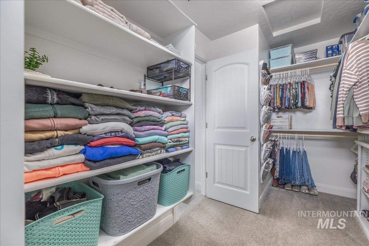 Spacious closet with light colored carpet