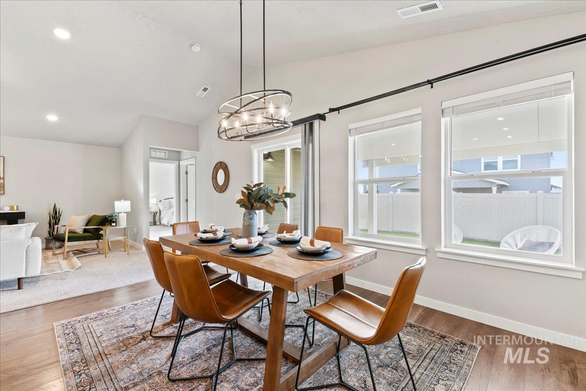 Dining space featuring recessed lighting, wood finished floors, vaulted ceiling, and a chandelier