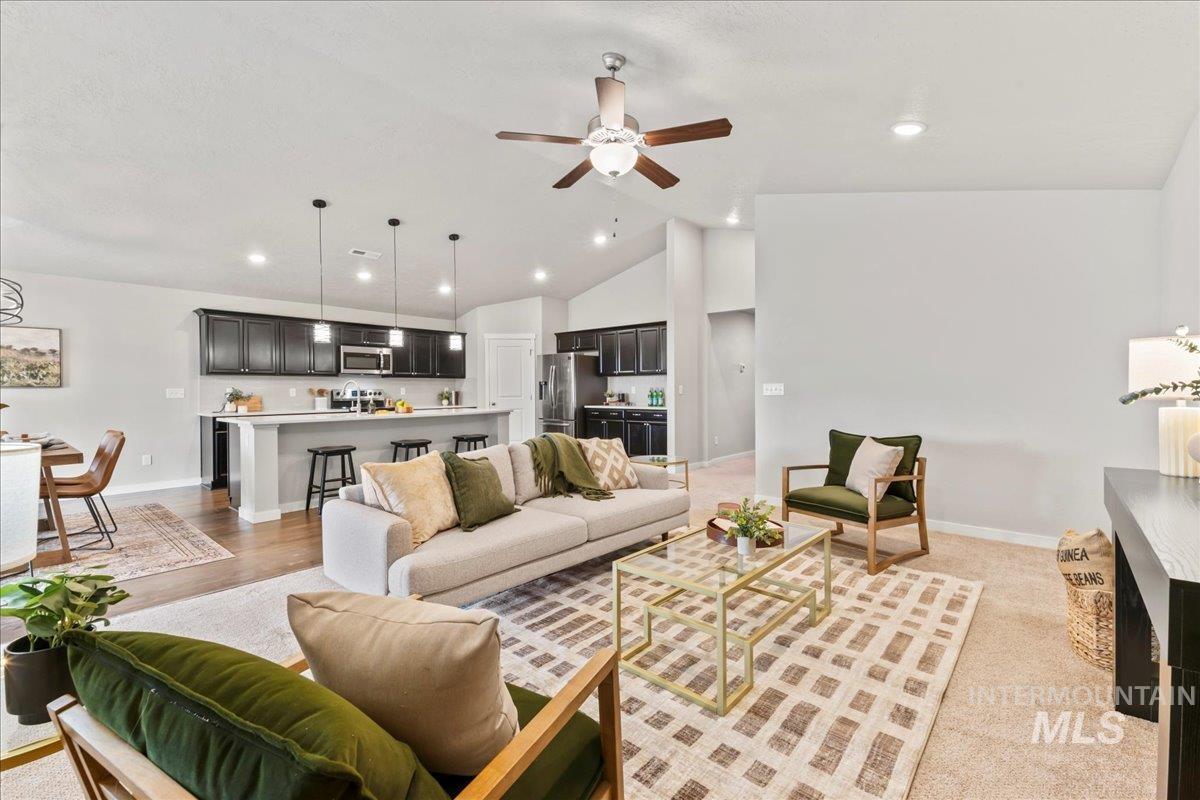 Living area featuring ceiling fan, high vaulted ceiling, recessed lighting, and light wood finished floors