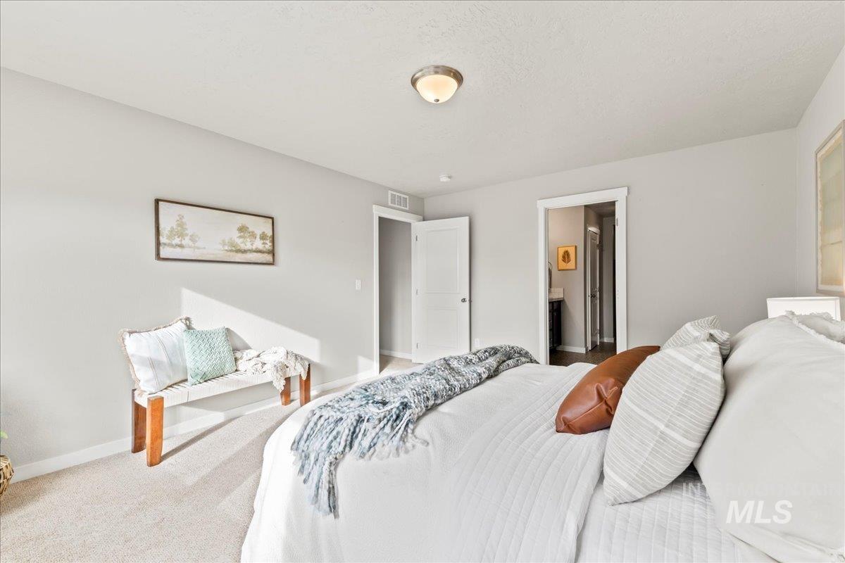 Carpeted bedroom with baseboards and ensuite bath
