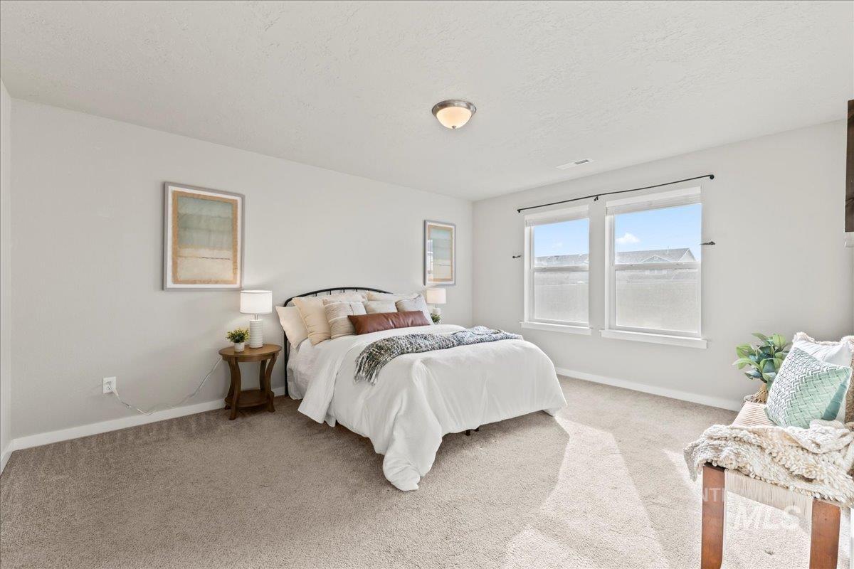 Bedroom featuring carpet and a textured ceiling