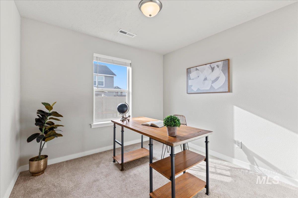 Home office featuring light colored carpet and baseboards