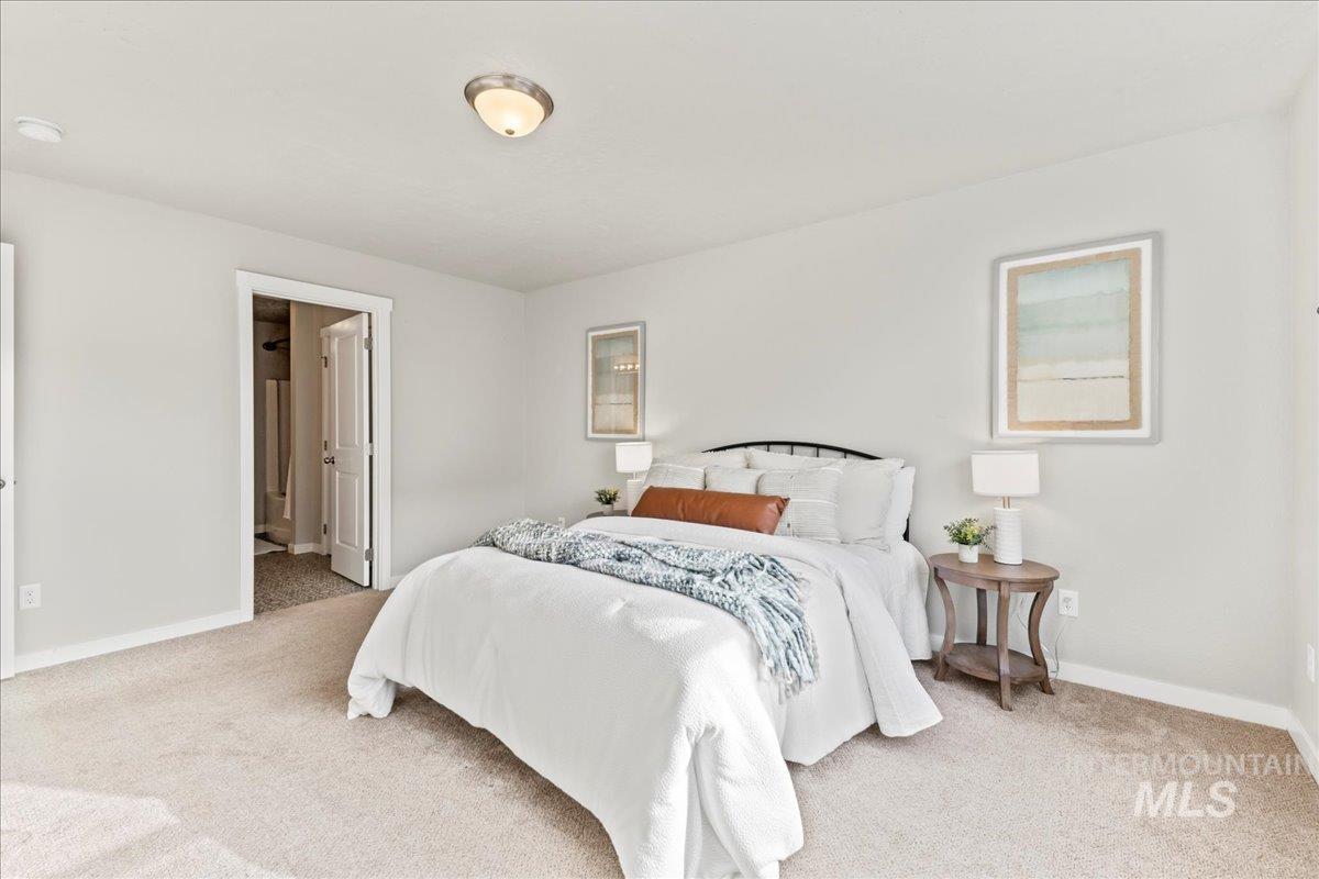 Bedroom with light carpet and ensuite bath