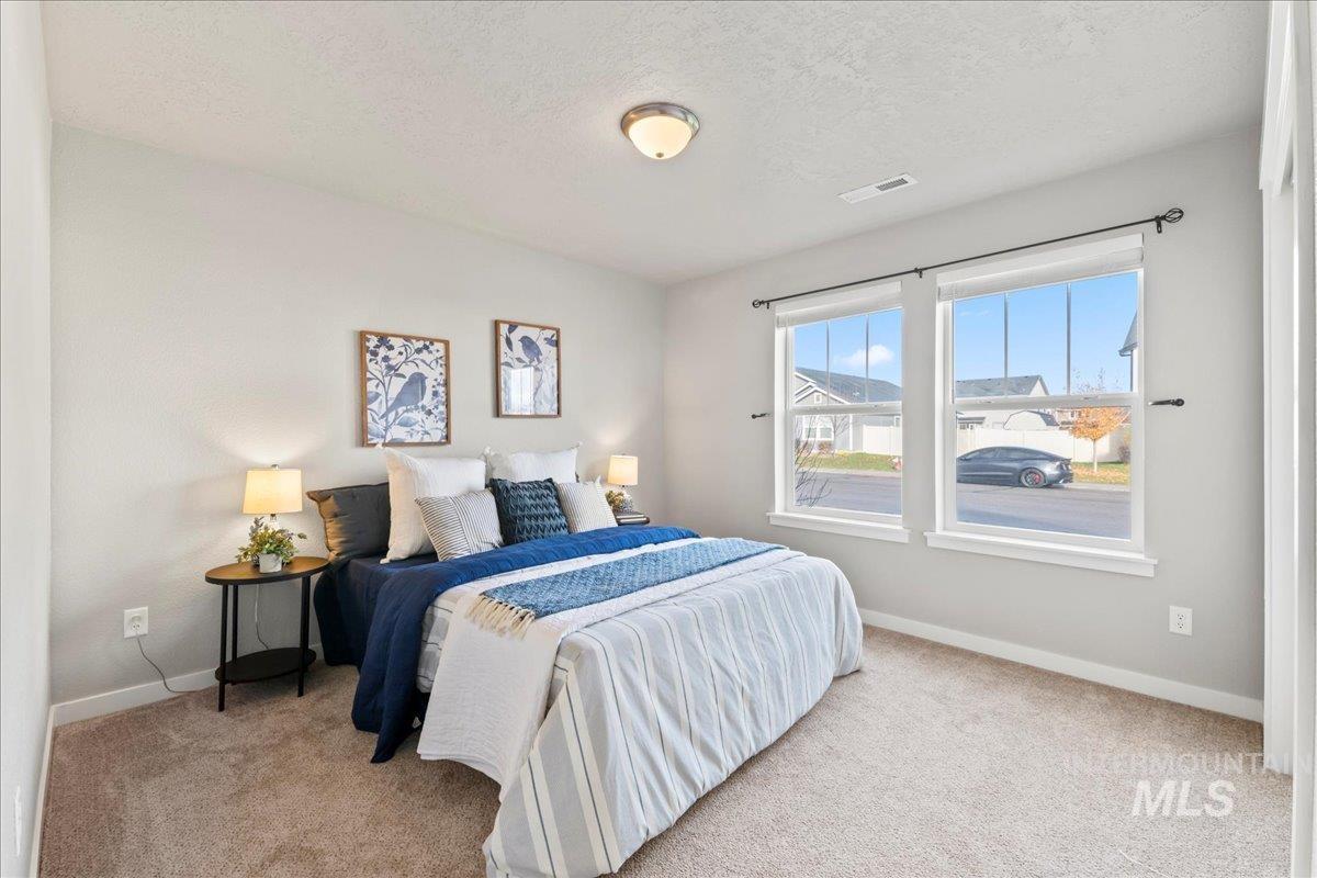 Bedroom featuring light carpet and a textured ceiling