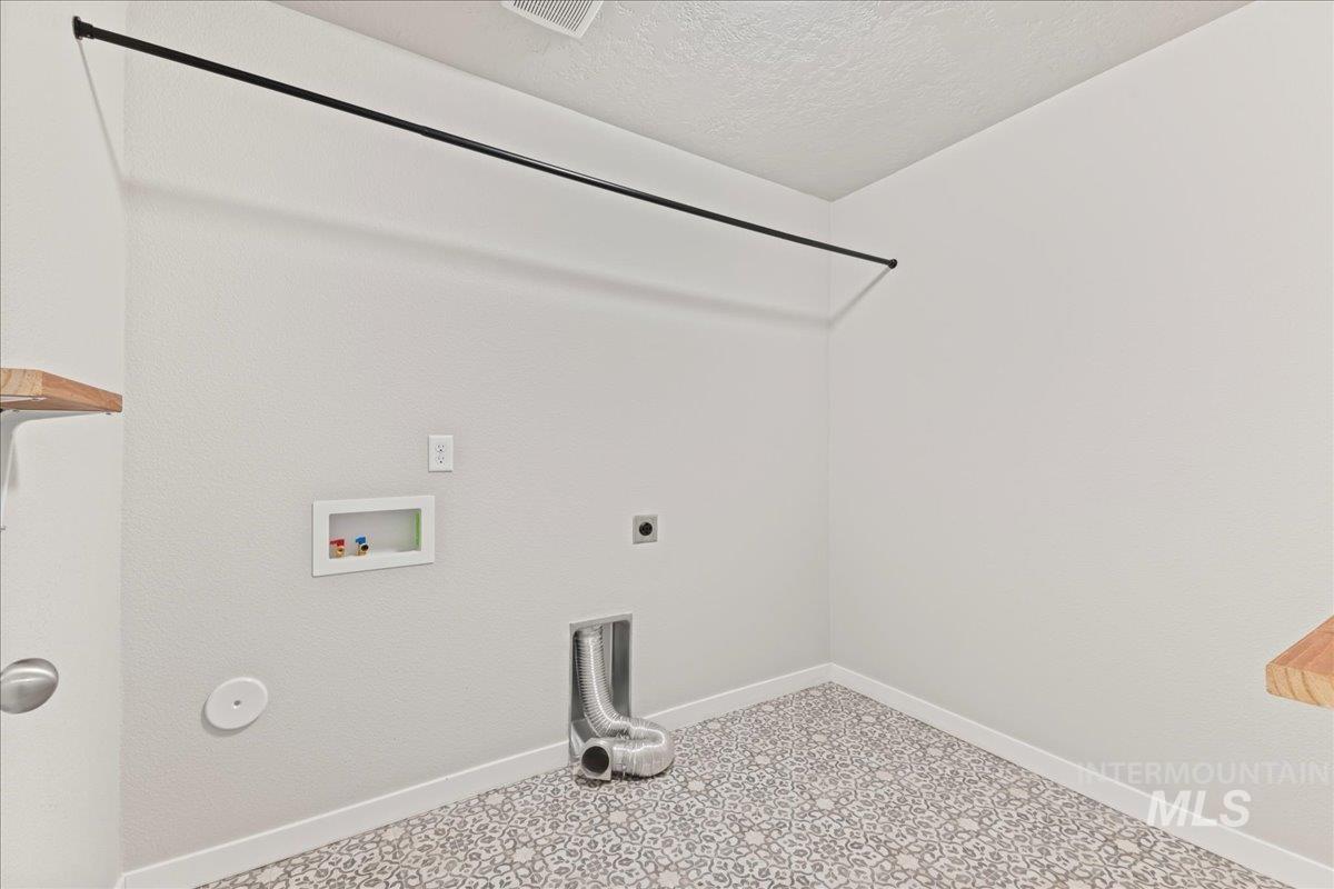 Washroom featuring washer hookup, a textured ceiling, and electric dryer hookup