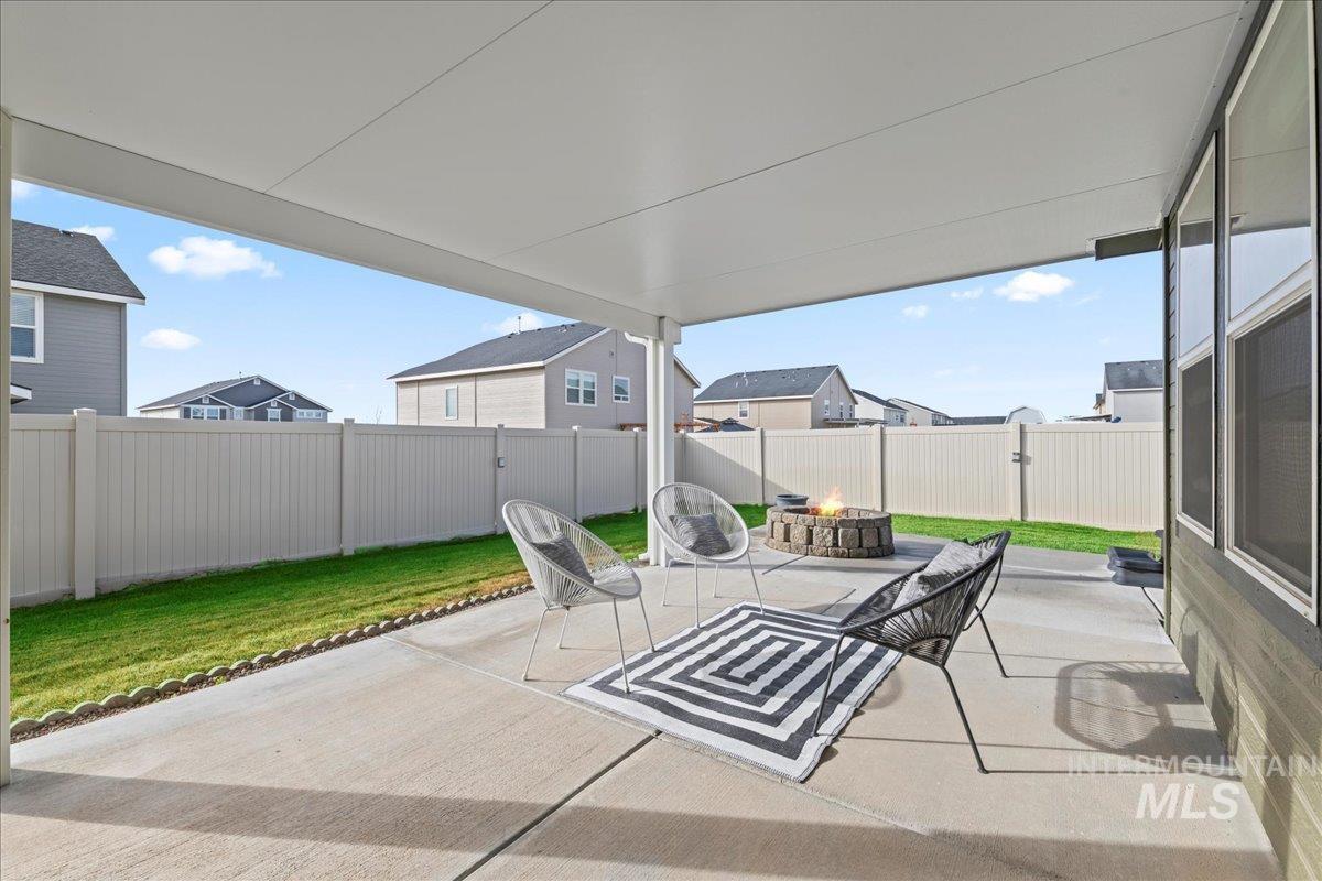 Fenced backyard featuring a fire pit and a patio
