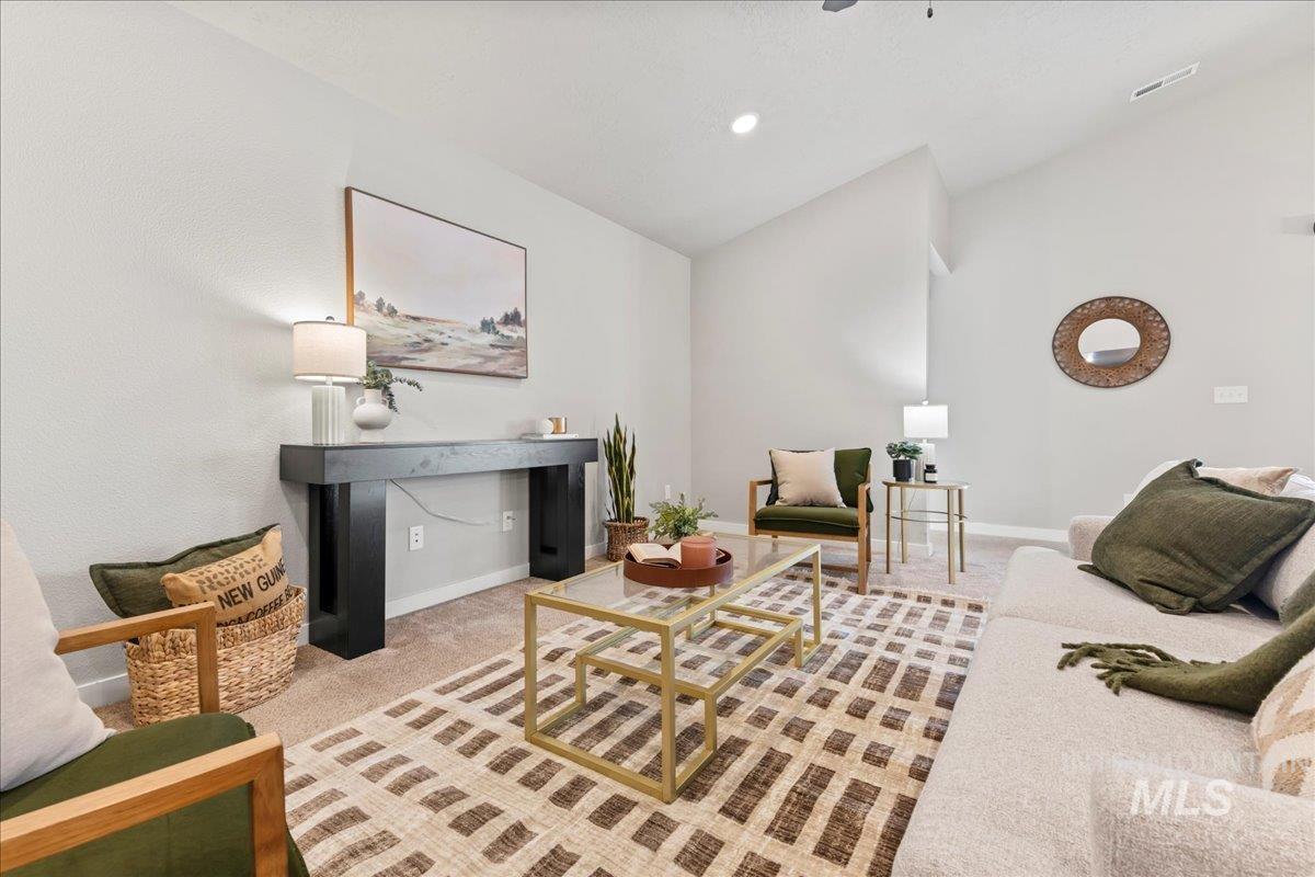 Living area featuring light carpet and vaulted ceiling