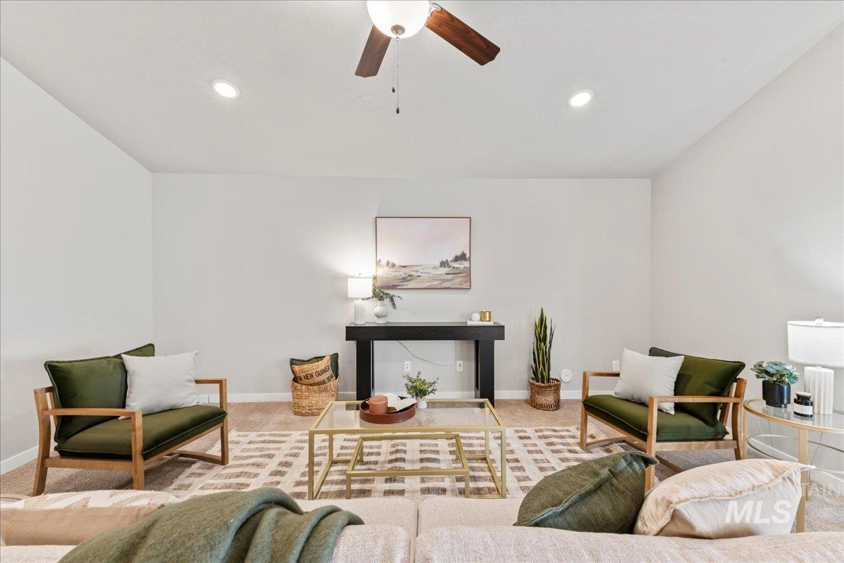 Carpeted living room with ceiling fan and recessed lighting